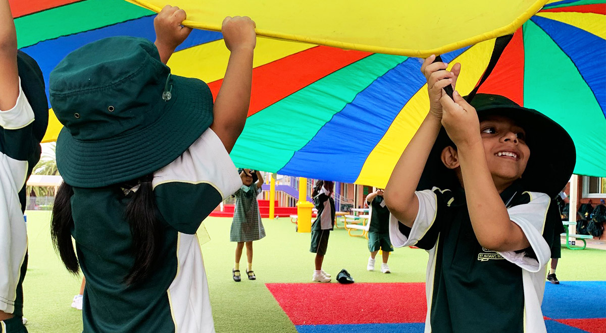 Students under rainbow parachute at St Aidan's Catholic Primary School Rooty Hill