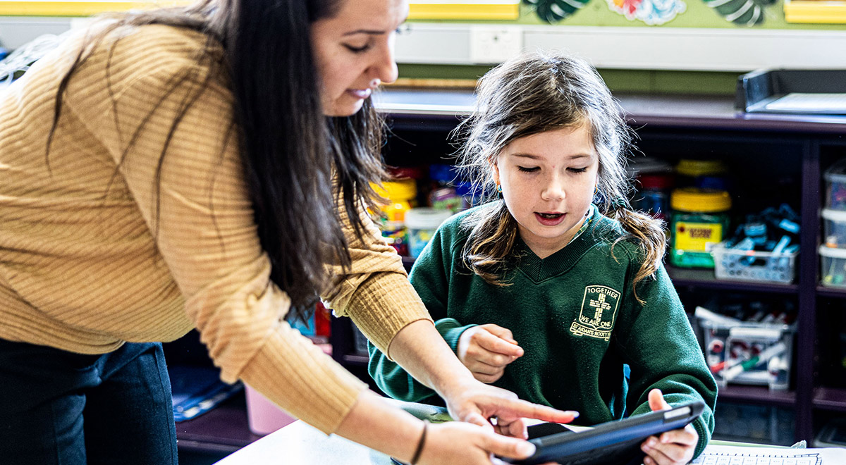 Dedicated teacher and student on iPad at St Aidan's Catholic Primary School Rooty Hill
