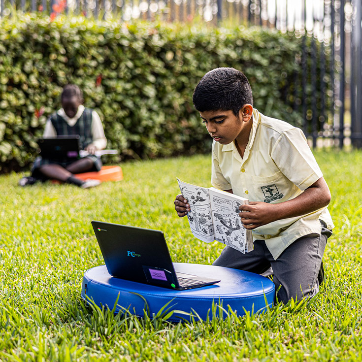 Student learning on grassy lawn at St Aidan's Catholic Primary School Rooty Hill